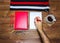 Note book and pencil with cup coffee on wooden table