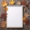 Note paper lying on the wooden floor surrounded by dry maple leaves.