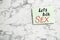 Note with phrase `LET`S TALK SEX` on marble background