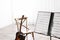 Note stand with music sheets and blurred acoustic guitar on background.