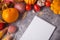 Notebook, autumn leaves, vegetables on the concrete background. Autumn harvest. Top view. Copy space