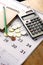 Notebook, coins, calendar, calculator and pencil on a table