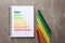 Notebook with colorful bars and markers on grey background. Energy efficiency rating chart