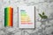 Notebook with colorful bars and markers on white marble background. Energy efficiency rating chart