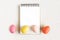 Notebook with Easter Eggs. Spiral notepad on spring white background. Top view of open writing pad with blank page