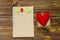 Notebook, felt heart on wooden background