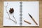 Notebook, gold pen and concert on the desk, dry cones and branches decorated table