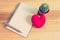 Notebook with heart and cactus on wooden background