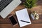 Notebook, laptop, clock, smartphone and pen on a wooden table