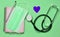 Notebook, pencil, stethoscope, decorative heart on a blue background. Medical equipment.