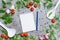 Notebook and pencil for writing recipes surrounded by cherry, dill, pepper spice, garlic and ladles on a gray background