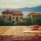 Notebook and pencils on old wooden table in front of romantic Provence rural landscape. retro filtered image