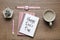 Notebook with phrase Happy Boss`s Day, coffee, wristwatch and plant on wooden table, flat lay