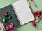 Notebook With Pink Flowers on a Green Background Pink magnolia flowers.