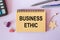 Notebook with text - Business Ethic - near office supplies