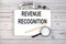 Notebook with text REVENUE RECOGNITION on the wooden table with pen, magnifier and glasses