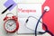 Notebook with word Menopause, alarm clock, stethoscope and paper on color background, flat lay