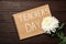 Notebook with words TEACHER`S DAY and flower on wooden table, flat lay