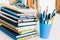 Notebooks piles, stack of books education back to school background, textbooks, glasses and pencils in plastic holder with copy