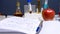 Notepad with the chemical formulas of additives E, test tubes and syringes, red apple next to it. Food laboratory. Close up on a