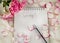 Notepad with inscription spring rose petals on a white background spring
