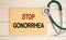 Notepad with the inscription Stop Gonorrhea and stethoscope