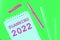 Notepad labeled Planning 2022  and multi-colored markers on light green background