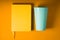 Notepad and plastic turquoise glass on a yellow background