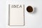 Notepad with word idea and a cup of coffee on white background. Creative ideas and plans. Copy space