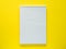 Notepad for writing on the yellow desktop, flat lay, copy space.