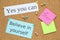 Notes with motivational quotes pinned to cork board, flat lay