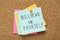 Notes with phrase Believe In Yourself pinned on corkboard, top view. Motivational quote