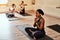 Nothing adds more to your life like meditation. a group of young men and women meditating in a yoga class.