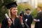 Nothing builds self-esteem and self-confidence like accomplishment. a young college graduate using her cellphone.
