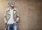 Nothing completes streetwear style than swag. a fashionable young man wearing urban wear and posing against a brown wall