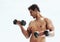 When nothing goes right, go lift. a shirtless young man working out with dumbbells outside.