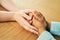 Nothing heals like the human touch. a man and woman holding hands in comfort on a table.