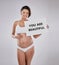 Nothing more beautiful than the pregnant body. Studio portrait of a beautiful young pregnant woman holding a sign with