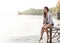Nothing more relaxing than being surrounded by water. an attractive young woman sitting on a pier.