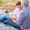 Nothing more romantic than a picnic. A loving mature couple enjoying an intimate picnic together in a scenic field.