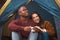 Nothing says romance like a tent, chirping birds and bae. a young couple drinking coffee while sitting in their tent.