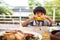 Nothing tastes better than a yellow vegetable. an adorable little boy eating a cob of corn around a table outdoors.