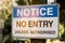 Notice. No entry unless authorised sign on a wooden pole