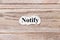 Notify of the word on paper. concept. Words of notify on a wooden background