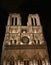 Notre Dame Cathedral at midnight. Facade, towers, rose window, archs and statues. Paris, France.