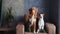 A Nova Scotia Retriever and a Jack Russell Terrier sit together on an armchair