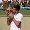 Novac Djokovic, Serbian player, wins Wimbledon for the fourth time. In the photo he kisses his trophy on centre court.