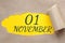 november 01. 01th day of the month, calendar date.Hole in paper with edges torn off. Yellow background is visible