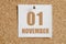 november 01. 01th day of the month, calendar date.White calendar sheet attached to brown cork board.Autumn month, day of