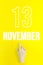 November 13rd. Day 13 of month, Calendar date.Hand finger pointing at a calendar date on yellow background.Autumn month, day of